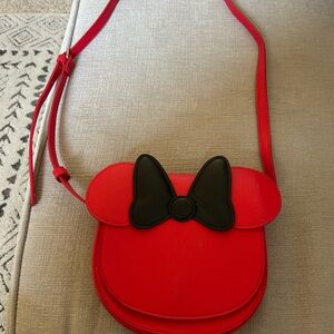 Disney red purse with magnetic closure and adjustable strap.